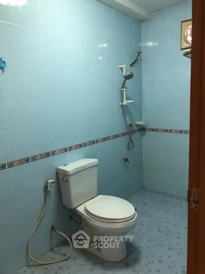 Spacious bathroom with blue tiles and modern shower in real estate property.