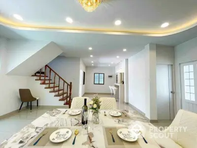 Elegant dining area with marble table and modern lighting in spacious open-plan home.