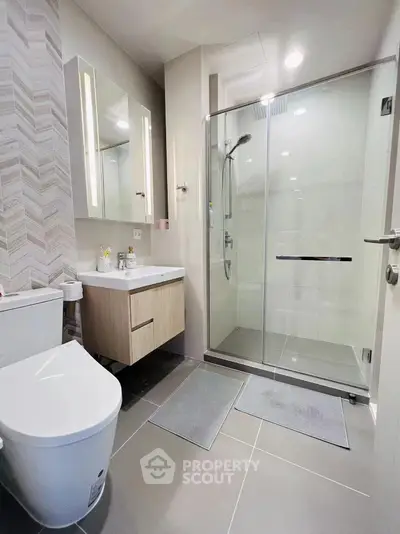Modern bathroom with glass shower and sleek fixtures in a contemporary apartment.