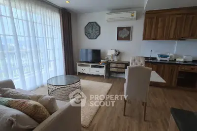 Charming living room with cozy seating, modern decor, and natural light in a stylish apartment.