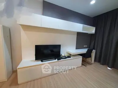 Modern living room with sleek white furniture and flat-screen TV, perfect for contemporary living.