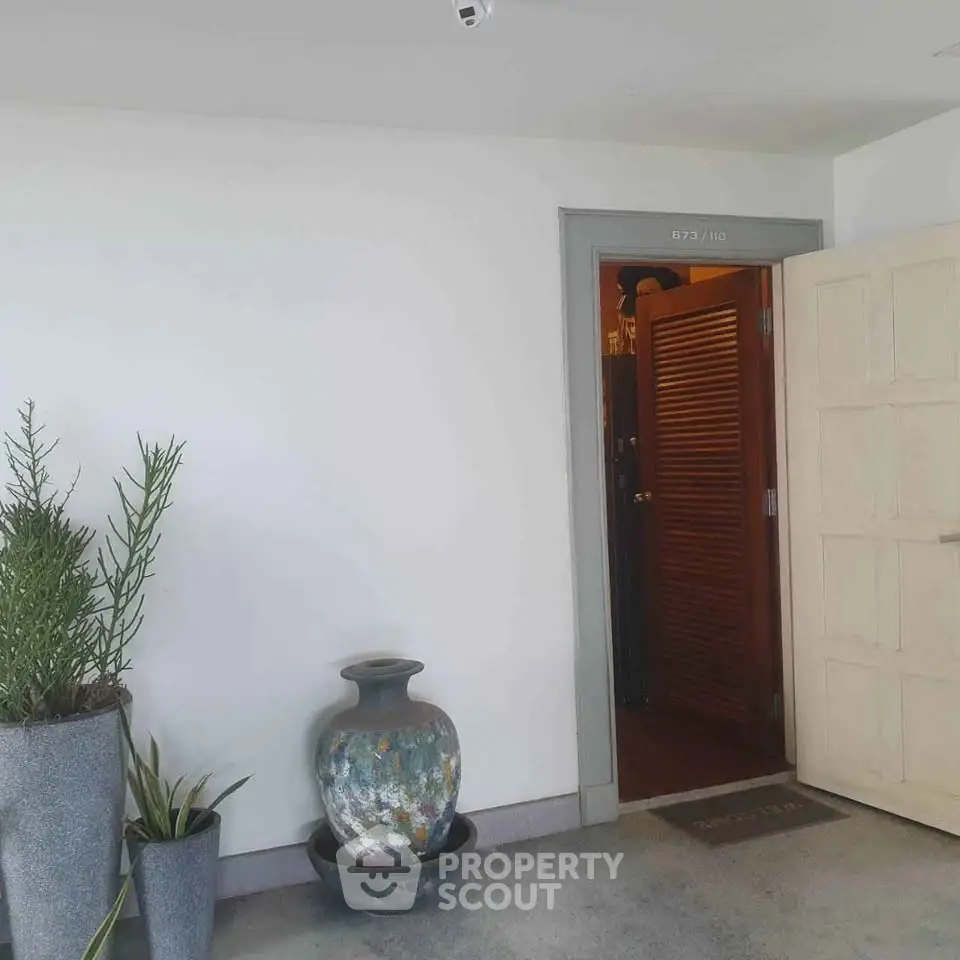 Chic apartment entrance with stylish decor and potted plants, offering a welcoming ambiance.