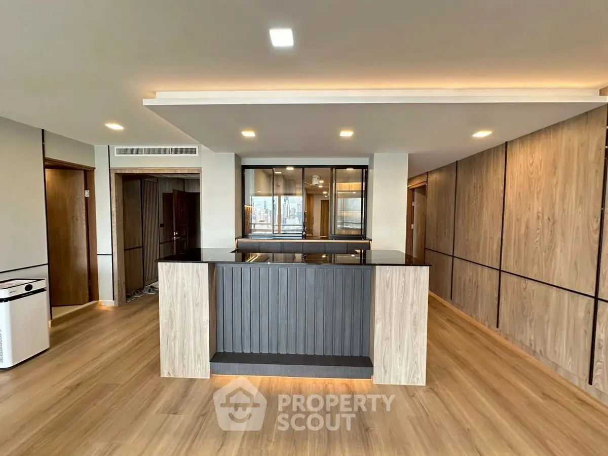Modern open-plan kitchen with sleek wooden finishes and ample natural light