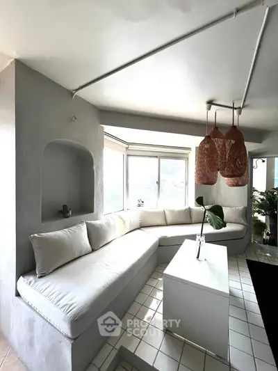 Bright and modern living room with cozy built-in seating and stylish pendant lights.
