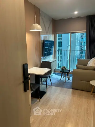 Modern living room with stylish decor and balcony view in a high-rise apartment