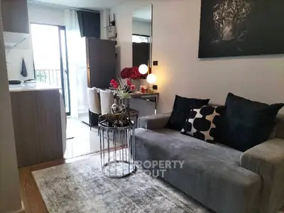 Modern living room with stylish decor and open kitchen layout in a cozy apartment.