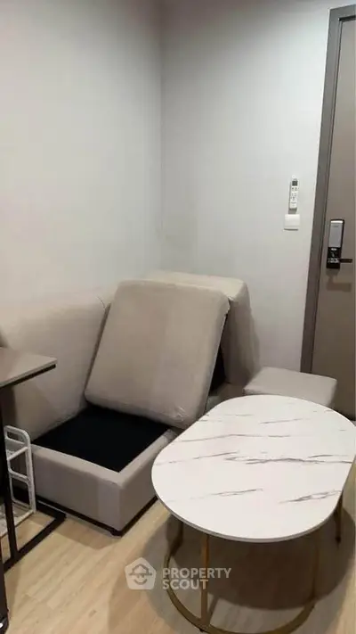 Cozy small living room with modern sofa and marble coffee table in a compact apartment.