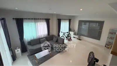 Spacious modern living room with sleek gray sofa and large windows for natural light.