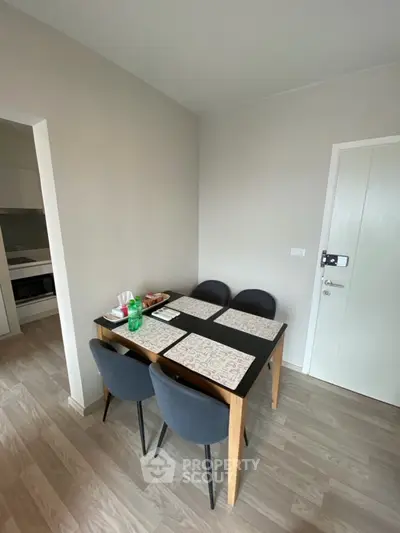 Modern dining area with sleek table and chairs in a cozy apartment setting.