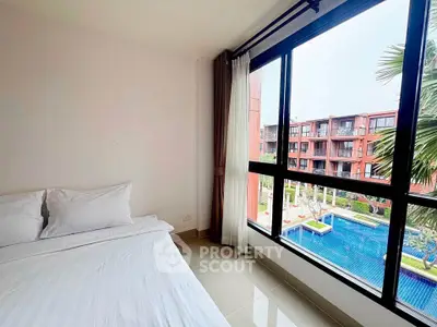Spacious bedroom with pool view in modern apartment complex