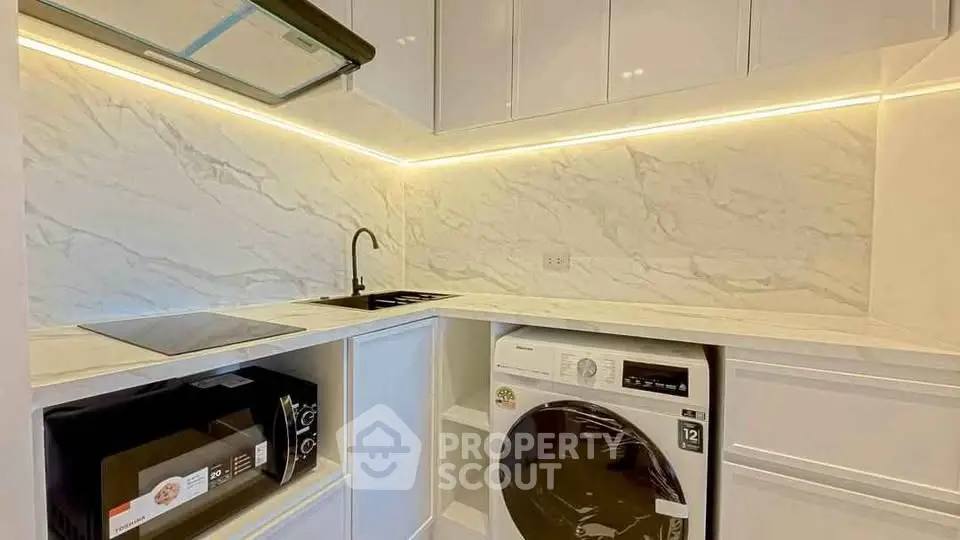 Modern kitchen with marble backsplash and built-in appliances