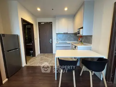 Modern kitchen with sleek design, featuring a compact dining area and stylish cabinetry.