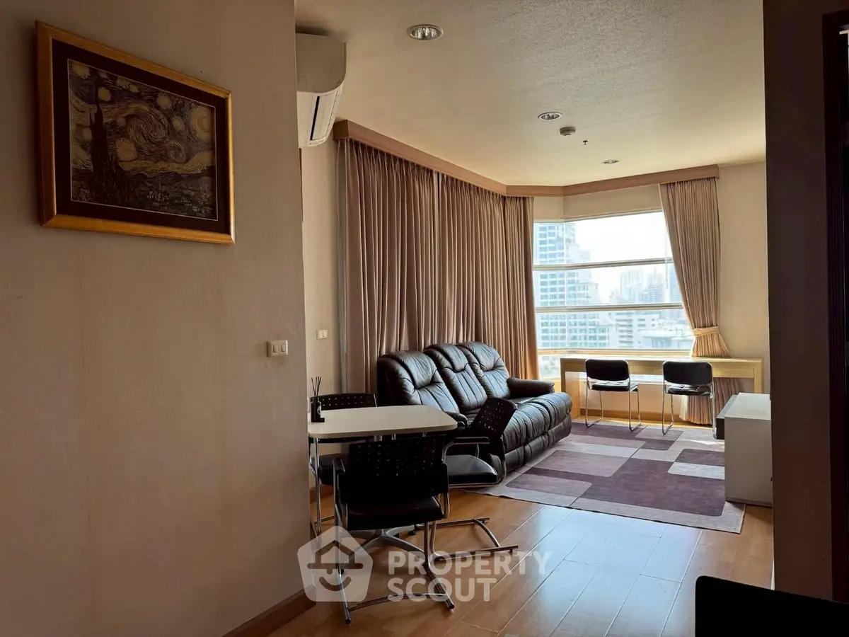 Spacious living room with city view, modern furniture, and natural light.
