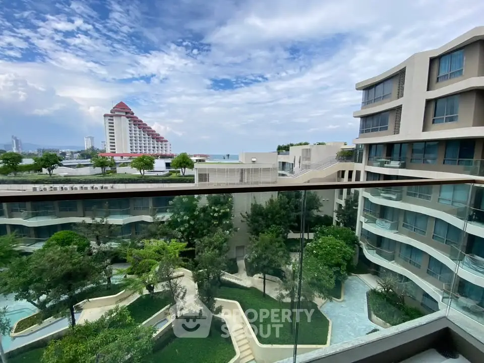 Stunning view from a modern balcony overlooking lush gardens and contemporary architecture.