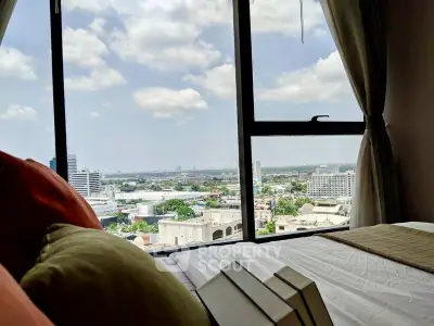 Stunning bedroom view with expansive cityscape through large window, perfect for urban living.