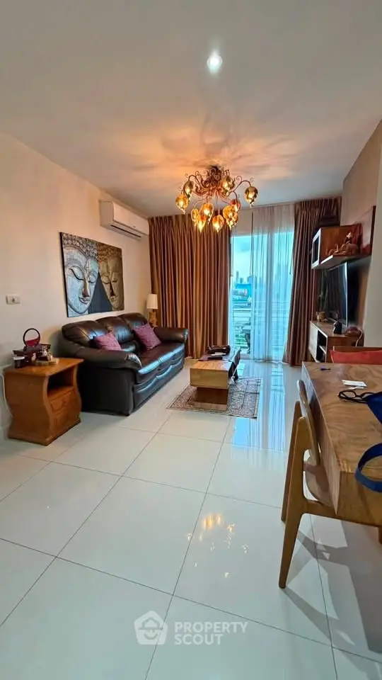 Stylish living room with city view, elegant chandelier, and modern decor in a high-rise apartment.
