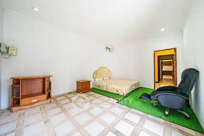 Spacious bedroom with unique flooring and cozy seating area