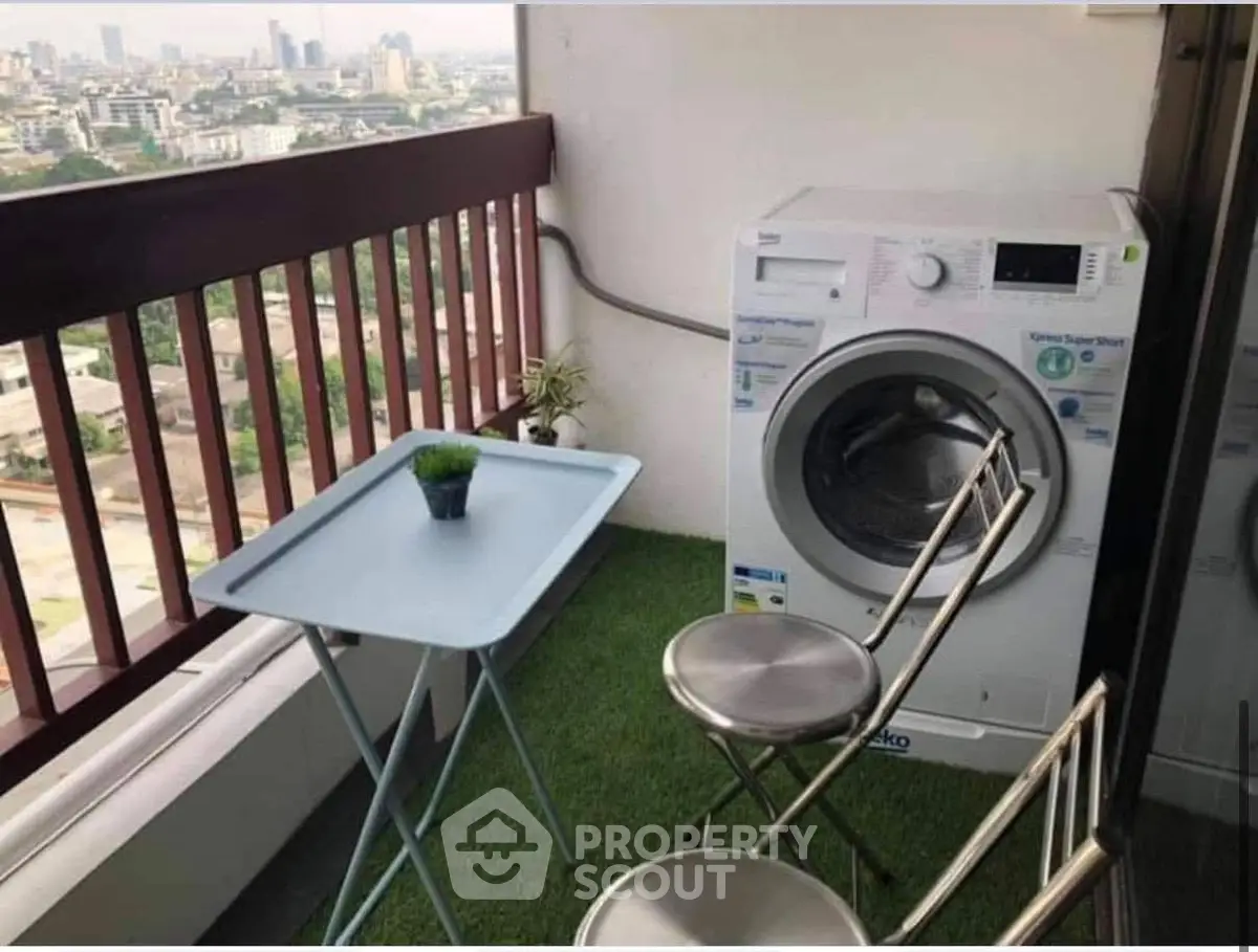 Charming balcony with city view, featuring a washing machine and cozy seating area.