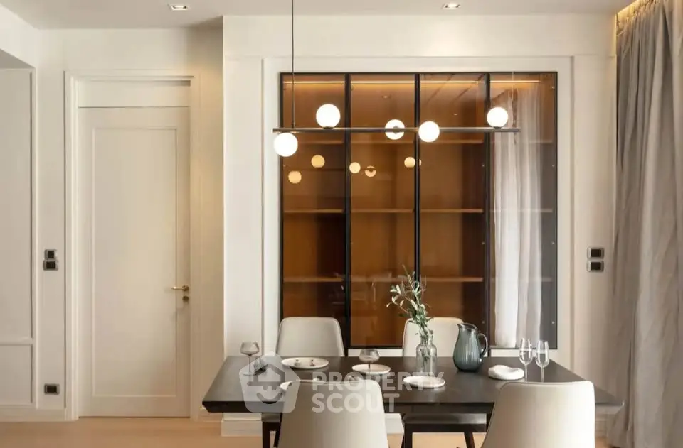 Elegant dining area with modern lighting and stylish decor in a contemporary apartment.