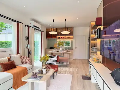 Modern living room with open kitchen, stylish decor, and natural light.