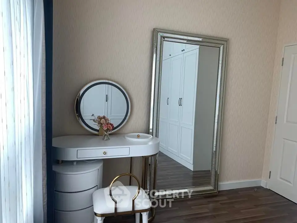 Elegant bedroom corner with vanity and large mirror, perfect for stylish living.