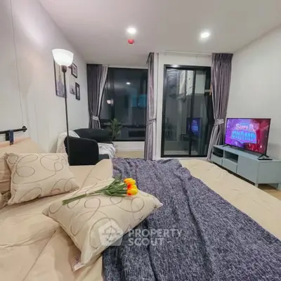 Cozy bedroom with modern decor and balcony access, featuring a stylish TV setup and elegant lighting.