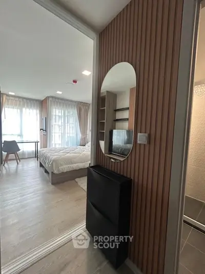 Modern bedroom with stylish decor and large windows offering natural light