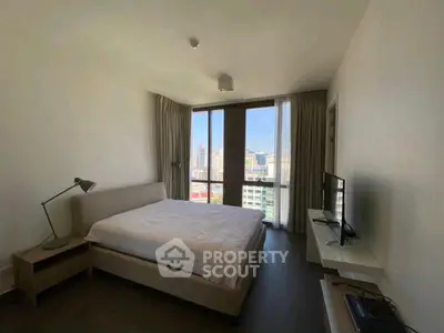 Modern bedroom with city view, featuring a cozy bed and sleek decor, perfect for urban living.