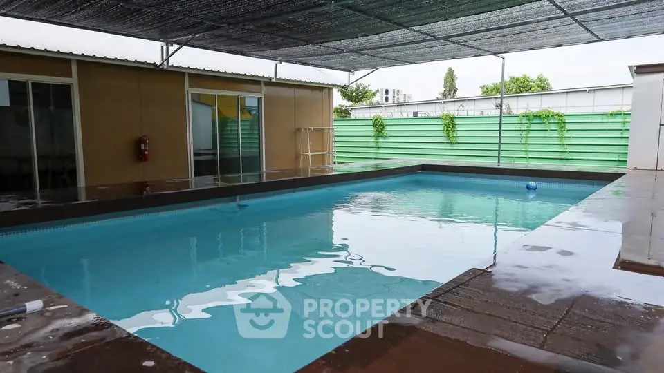 Spacious covered swimming pool area with modern design and privacy features.