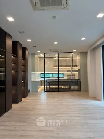 Spacious modern living room with open kitchen and sleek glass partitions
