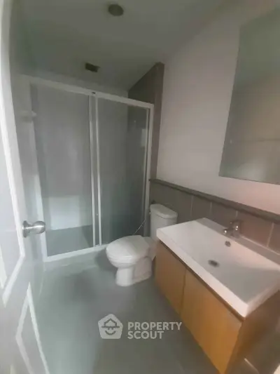 Modern bathroom with sleek shower and contemporary fixtures in a stylish real estate property.
