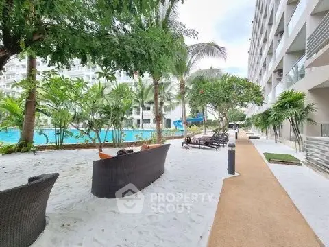 Luxurious outdoor pool area with lush greenery and modern seating in a high-end residential complex.