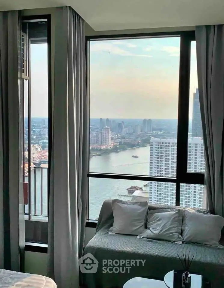 Stunning high-rise apartment with panoramic river view and cozy seating area.