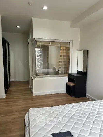 Modern bedroom with large window and sleek furniture in a high-rise apartment.