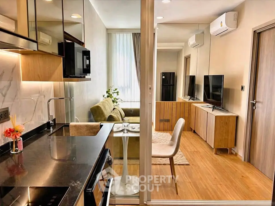 Modern open-layout living room and kitchen with stylish decor and natural light.