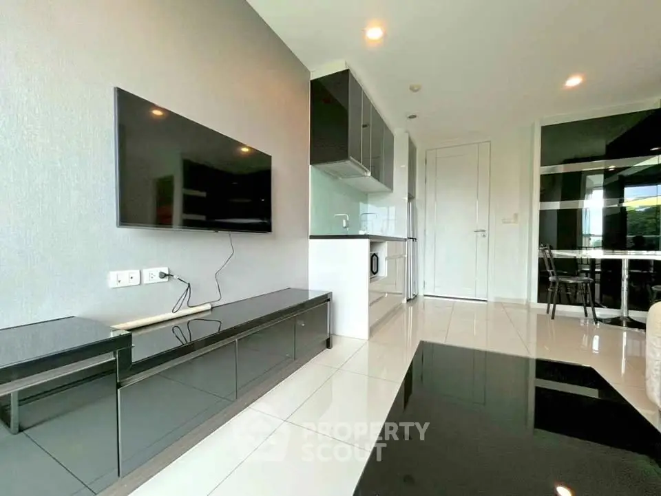 Modern living room with sleek TV setup and open kitchen layout