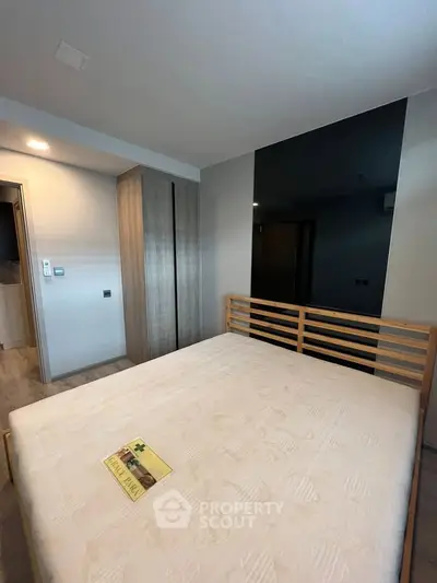 Modern bedroom with wooden bed frame and built-in wardrobe in a stylish apartment.