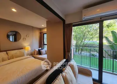 Charming bedroom with balcony view, cozy seating, and modern decor in a serene setting.