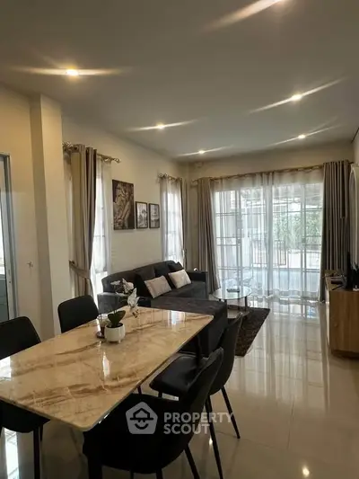 Spacious living room with elegant dining area and large windows for natural light.