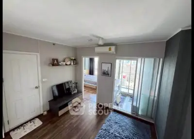 Modern living room with wooden flooring, air conditioning, and access to a balcony with city views.