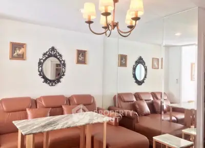 Elegant living room with leather sofas, marble table, and decorative mirrors creating a luxurious ambiance.