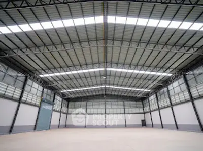 Spacious industrial warehouse with high ceilings and ample natural light.
