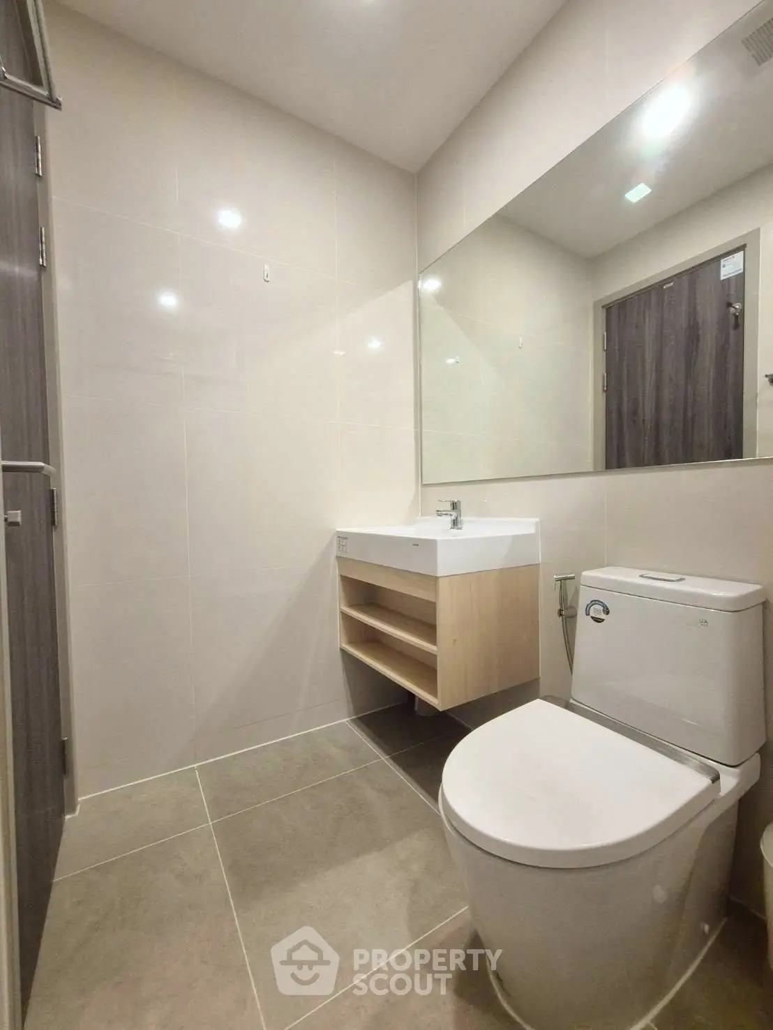 Modern bathroom with sleek fixtures and large mirror in contemporary apartment.