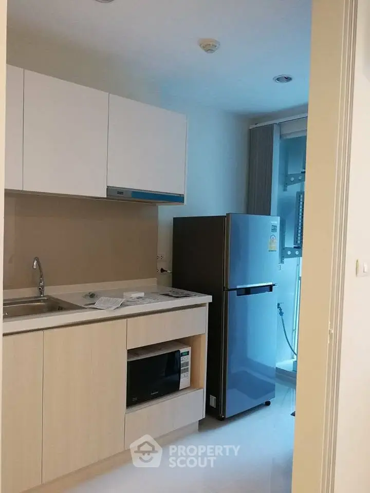 Modern kitchen with sleek cabinetry and stainless steel appliances in a compact layout.
