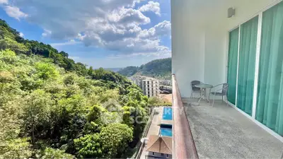 Stunning balcony view overlooking lush greenery and distant buildings, perfect for relaxation.