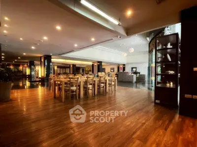 Spacious and elegant dining area with wooden flooring and modern lighting, perfect for gatherings.