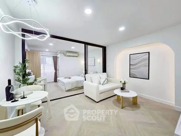 Modern open-plan living room with stylish decor and cozy bedroom view