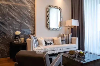 Luxurious living room with elegant decor and stylish furniture, featuring a plush sofa and modern lighting.