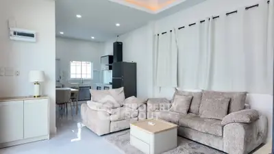 Spacious modern living room with cozy seating and open kitchen layout, perfect for family gatherings.