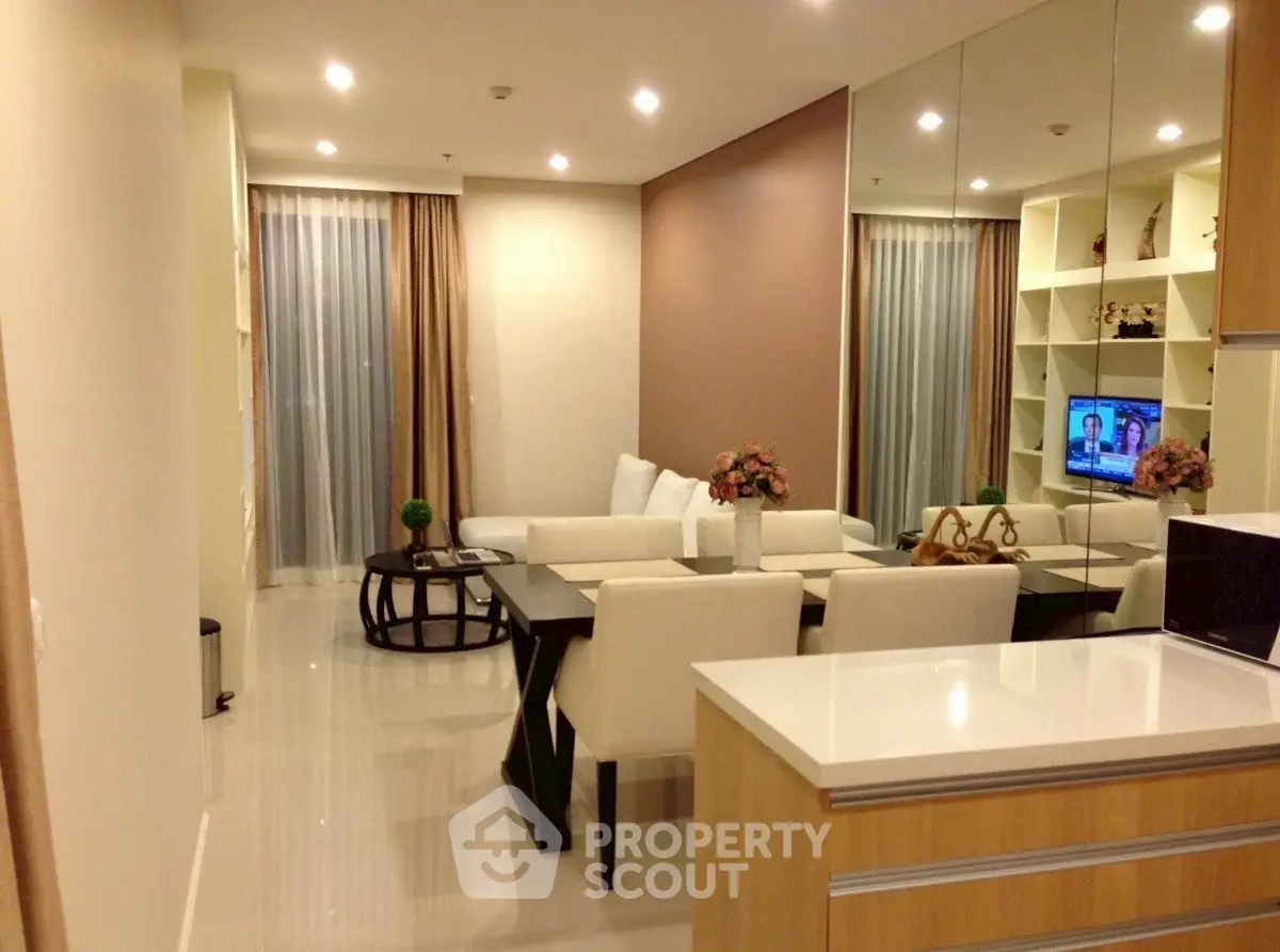 Modern living room with elegant decor and open layout, featuring a cozy seating area and stylish dining space.